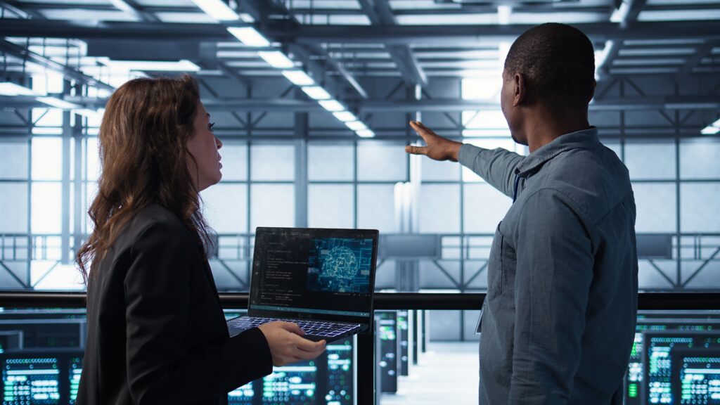 programmers coding on laptop using artificial intelligence in server farm